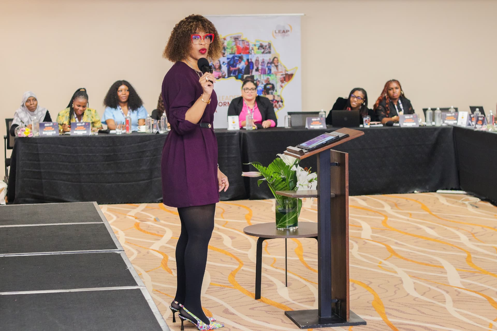 Amabelle speaking to a room of leaders, microphone in hand